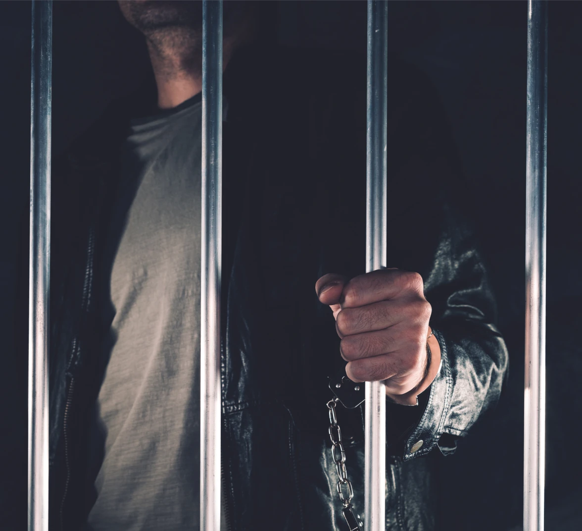 Individual imprisoned with handcuffs visible